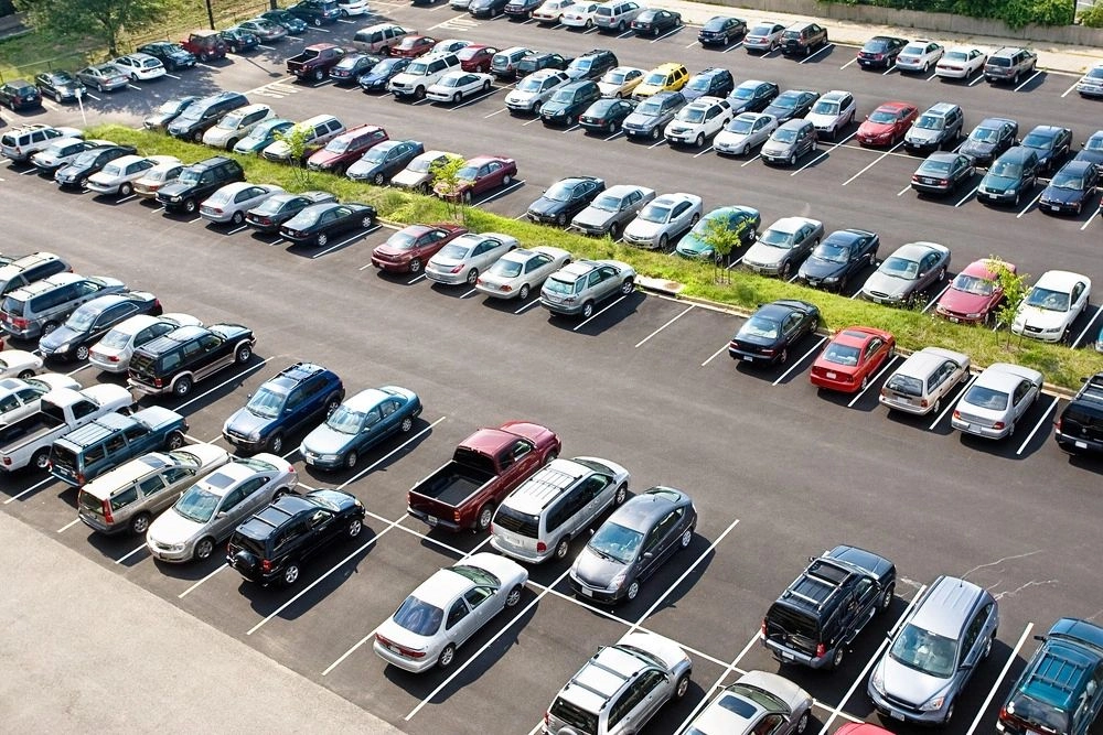 A parking lot filled with lots of cars parked.